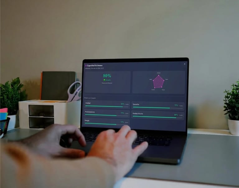 Person using computer mouse at desk with monitor displaying 3D design software interface and purple geometric shape